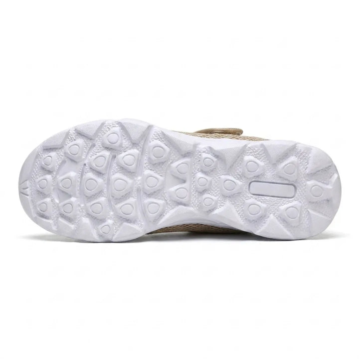 Dessous de la semelle blanche cranté de motifs triangulaires et arrondis antidérapants, avec la sangle beige visible au bord. 36