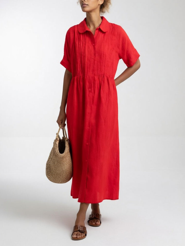 Robe rouge portée par une femme, main derrière le dos, panier en paille à la main, vue de face. 5