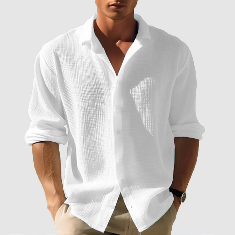 Homme portant la chemise texturée blanche, manches retroussées, col ouvert, avec un pantalon beige et une montre au poignet. 2