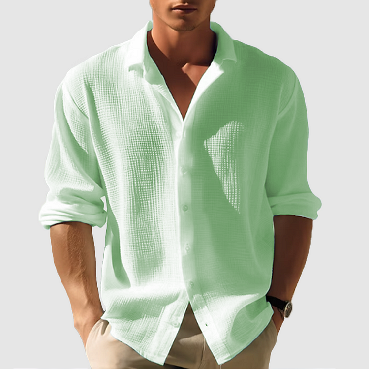 Homme portant la chemise texturée vert menthe clair, manches retroussées, boutonnée devant, avec un pantalon beige. 3
