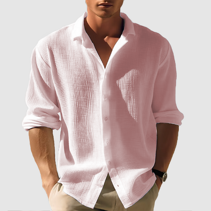 Homme portant la chemise texturée rose pâle, manches retroussées, coupe décontractée, avec un pantalon beige. 4