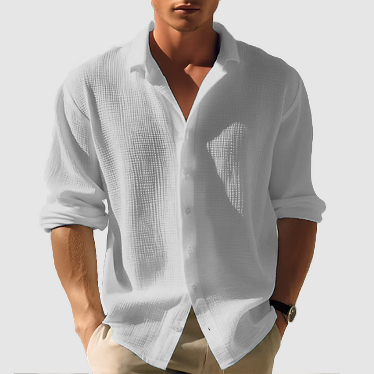 Homme portant la chemise texturée gris très clair, manches retroussées, boutonnée devant, avec un pantalon beige. 6