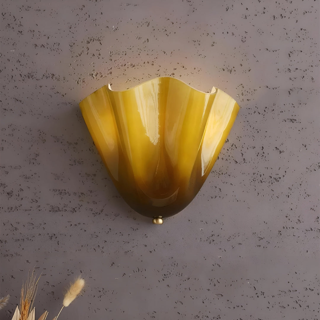 Détail de l'applique jaune ambré au verre veiné et reflets brillants, fixée sur un mur gris texturé. 11