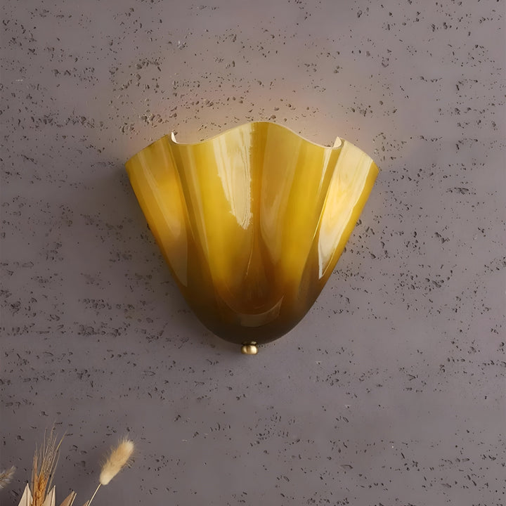 Détail de l'applique jaune ambré au verre veiné et reflets brillants, fixée sur un mur gris texturé. 11