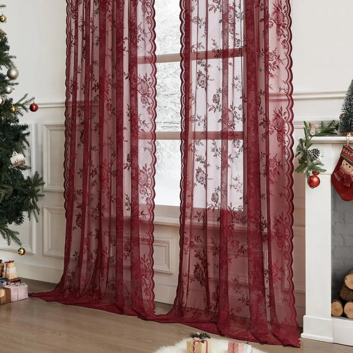 Deux panneaux de dentelle rouge bordeaux à roses devant une fenêtre, dans un décor de Noël avec sapin et cheminée. 2