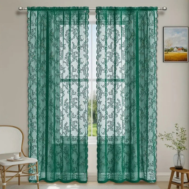 Deux panneaux de dentelle florale verts accrochés à une tringle devant une fenêtre, dans une pièce claire avec fauteuil et tableau. 5