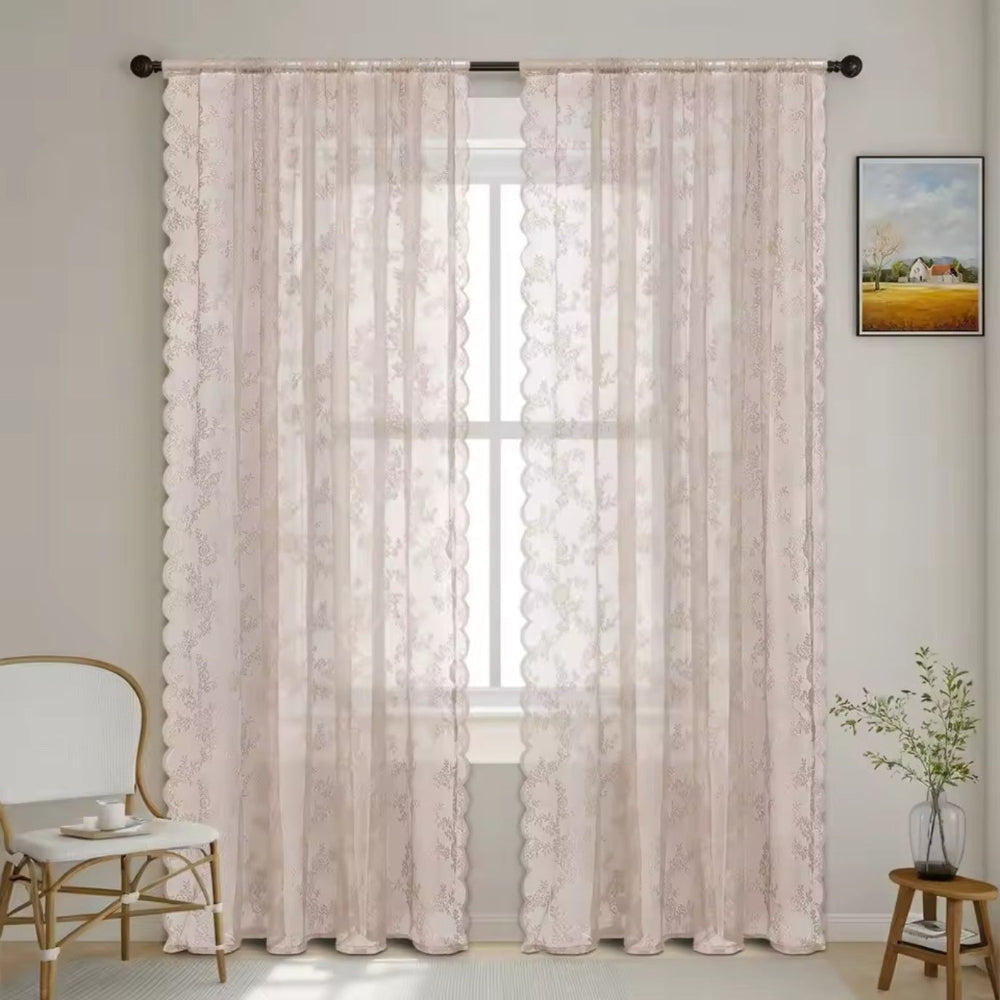 Deux panneaux de dentelle florale rose pâle à bord festonné devant une fenêtre, avec chaise blanche, plante et tableau. 9