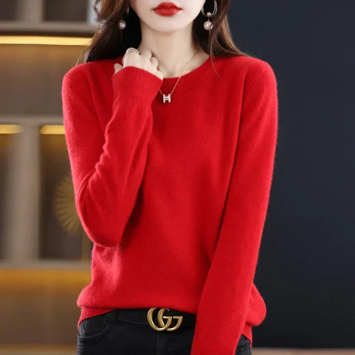Pull col rond rouge vif porté avec un pantalon noir et une ceinture, main près du col 9