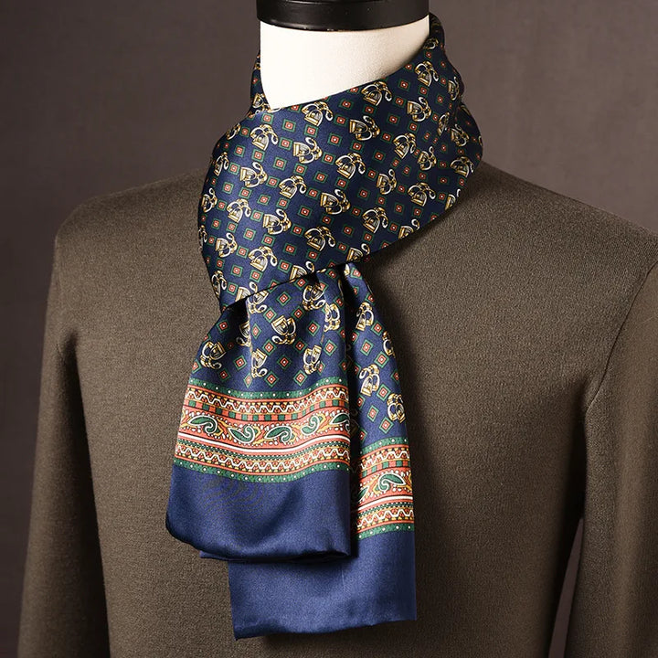 Foulard en soie bleu marine à motifs dorés et losanges, bordure colorée de cachemires, sur mannequin avec pull kaki. 20