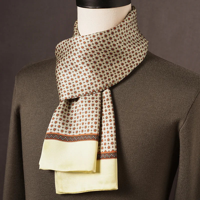 Foulard en soie crème à petits motifs orange et bordure jaune pâle, porté sur un mannequin avec pull kaki. 9