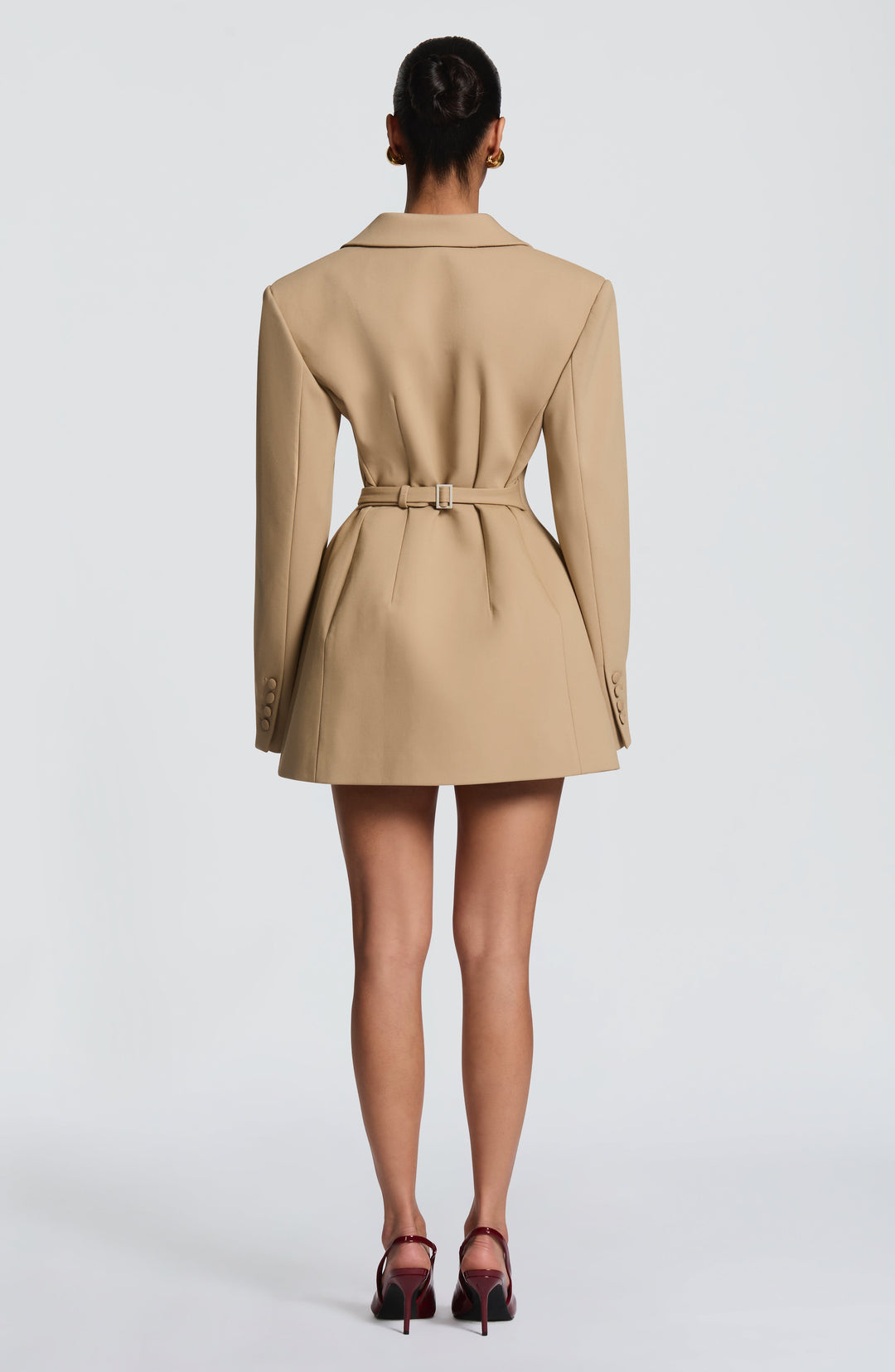 Vue de dos de la robe blazer beige, avec ceinture bouclée à la taille et boutons recouverts aux poignets. 23
