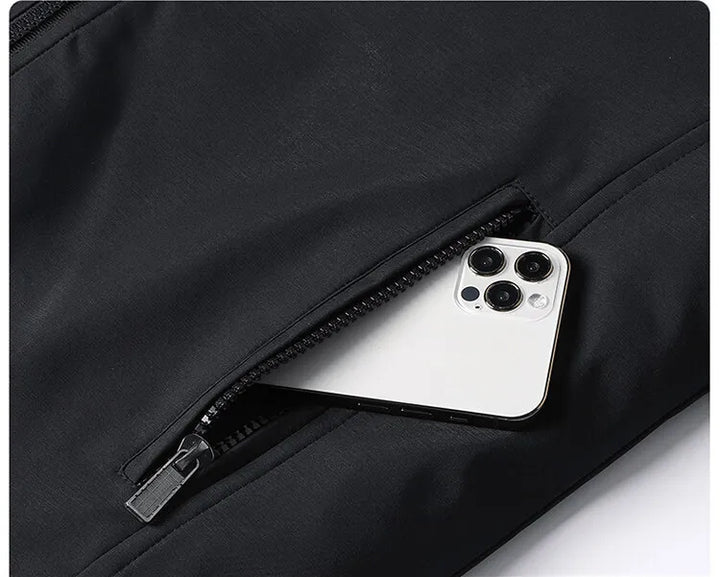 Poche zippée de la veste noire, entrouverte avec un smartphone blanc qui en dépasse. 7