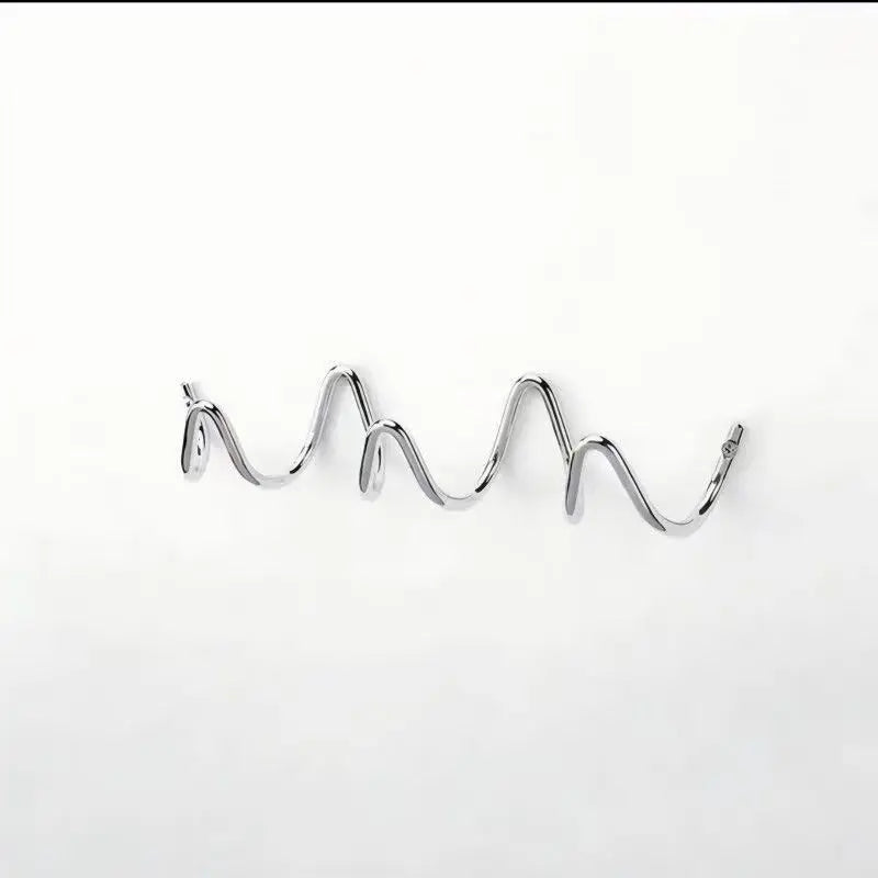 Portant en métal chromé argenté, vu de face et légèrement de côté sur fond blanc, avec ses boucles ondulées. 10