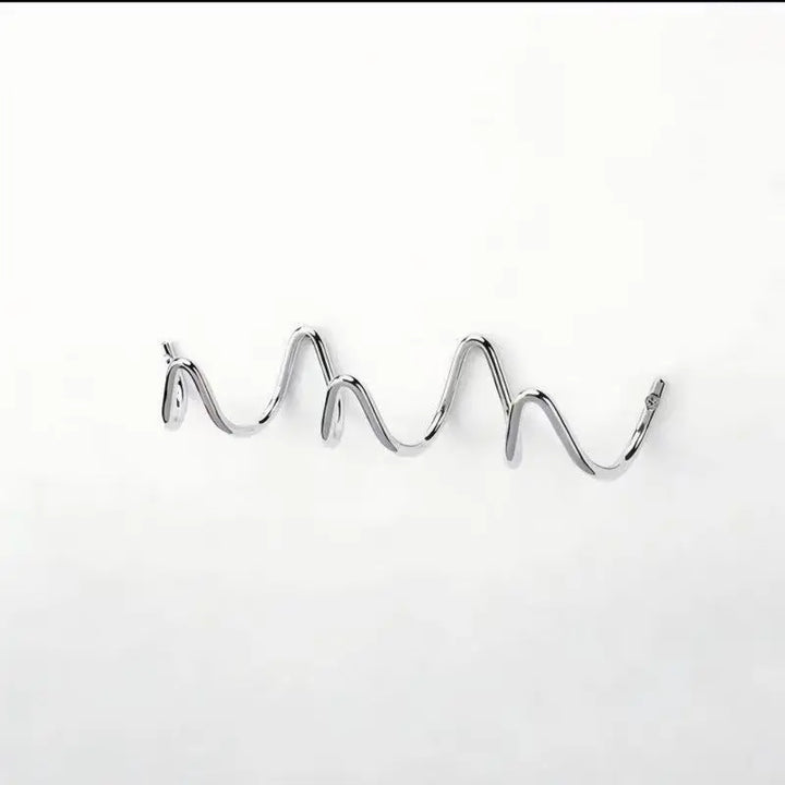 Portant en métal chromé argenté, vu de face et légèrement de côté sur fond blanc, avec ses boucles ondulées. 10