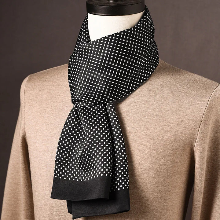 Foulard en soie noir à pois blancs et bordure noire unie, noué sur un mannequin avec pull beige. 14