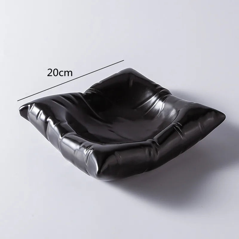 Saladier noir brillant vide sur fond clair, aux bords froissés en relief, avec une indication de largeur de 20 cm. 6