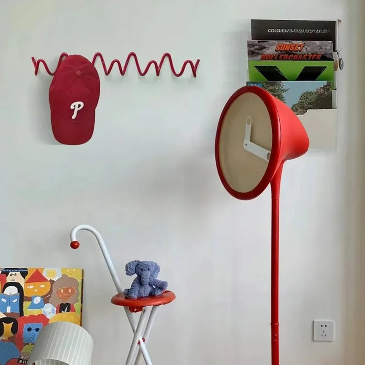 Portant rouge ondulé fixé au mur d'une chambre, portant une casquette rouge, au-dessus d'un tabouret et d'une horloge sur pied. 3