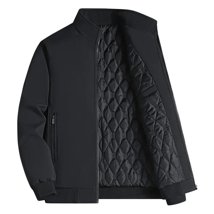 Veste noire à col montant entrouverte sur sa doublure matelassée en losanges, poche zippée sur le côté, fond blanc. 1