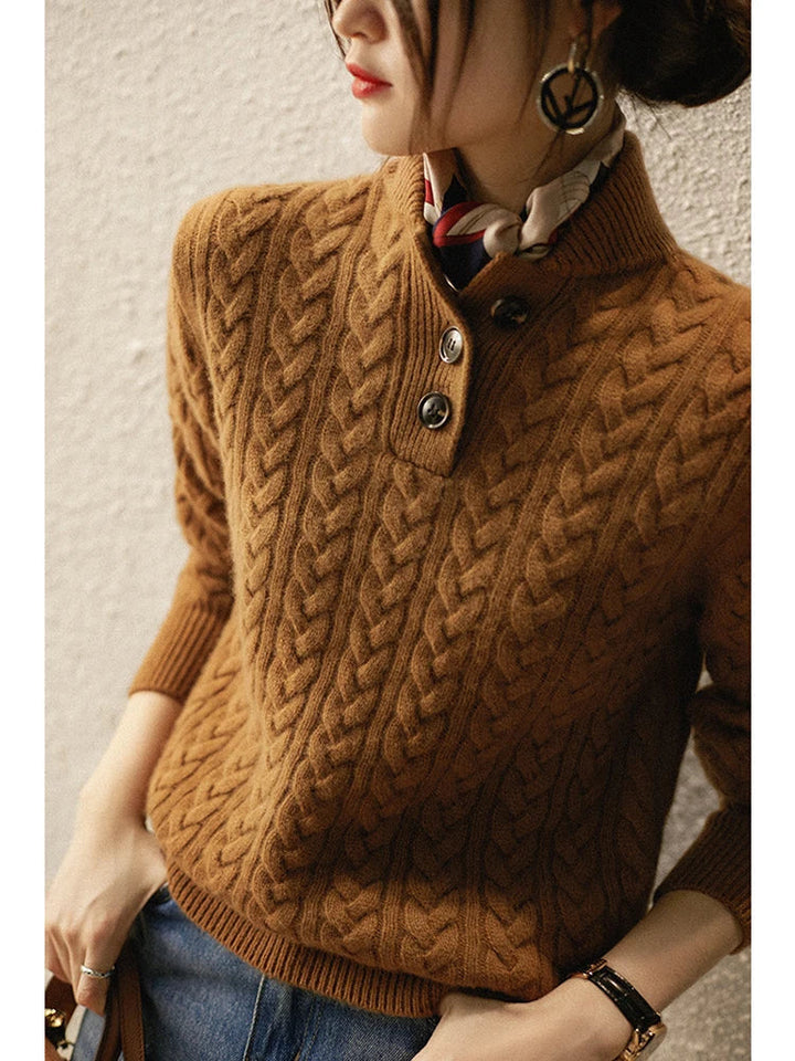 Pull camel torsadé porté avec un foulard au col, boucles d'oreilles rondes et jean, modèle appuyée contre un mur clair. 4