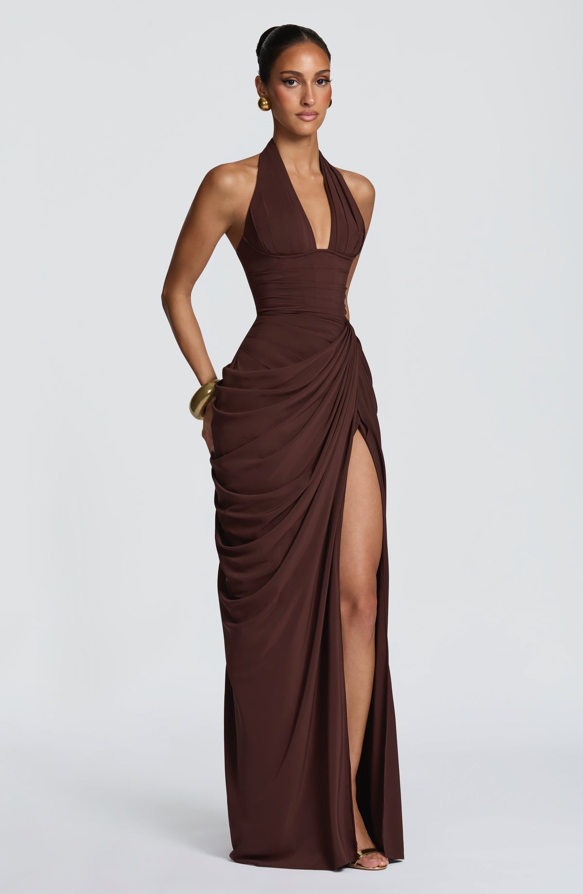 Robe marron vue de trois quarts, une main posée sur la hanche, jupe drapée laissant apparaître la jambe par la fente. 27