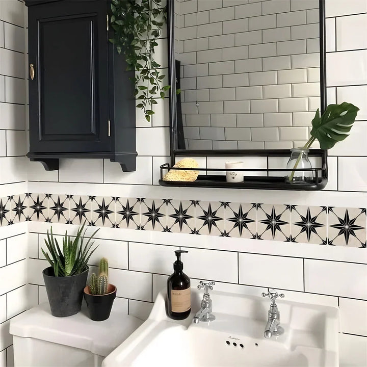 Frise à étoiles noires sur fond clair collée sur un carrelage blanc de salle de bain, au-dessus du lavabo 62