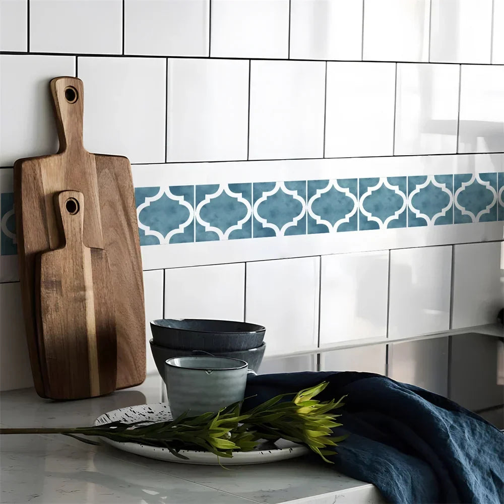 Frise à motifs bleus en arabesques collée sur un carrelage blanc de cuisine, près de planches en bois 64
