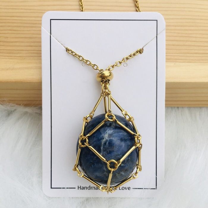 Collier doré avec filet autour d'une pierre sphérique bleu profond veinée de blanc, présenté sur une carte blanche. 12