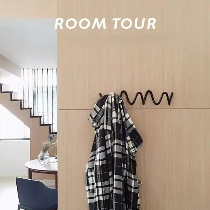 Portant noir ondulé sur un mur en bois clair, avec une chemise à carreaux noirs et blancs accrochée, dans un intérieur avec escalier. 7