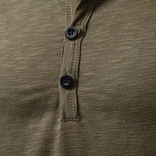 Gros plan sur la patte de boutonnage verte avec deux boutons sombres et surpiqûres apparentes 7