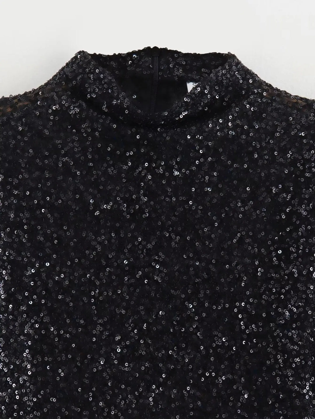 Gros plan sur le haut de la robe noire, paillettes serrées et col montant 4