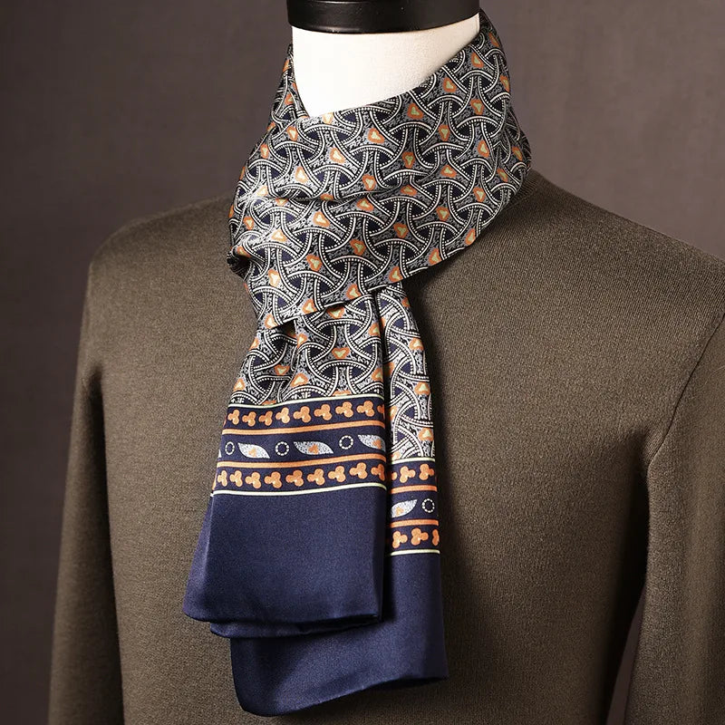 Foulard en soie bleu marine à motif d'arceaux gris et orange, bordure ornementale marine, sur mannequin avec pull kaki. 11