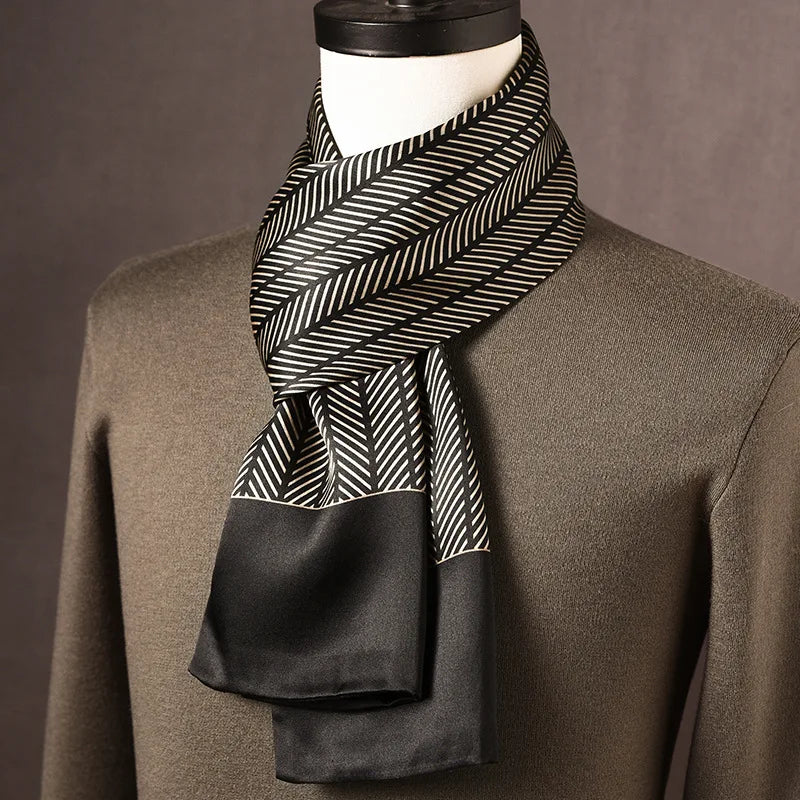 Foulard en soie noir et crème à motif de chevrons, bordure noire unie, porté sur un mannequin avec pull kaki. 4