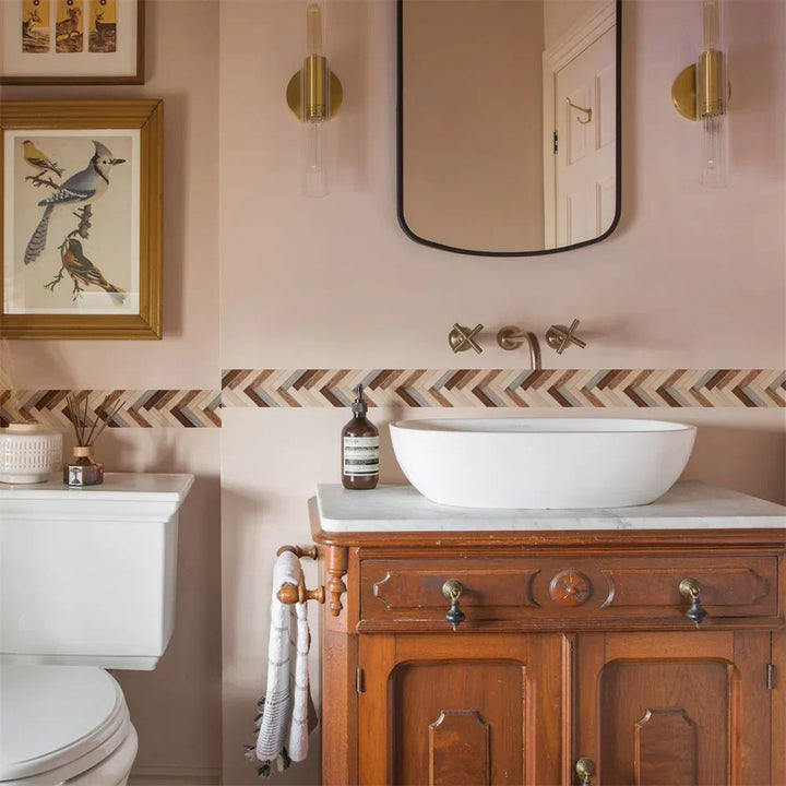 Frise à chevrons brun, beige et gris dans une salle de bain rose, au-dessus d'une vasque 7