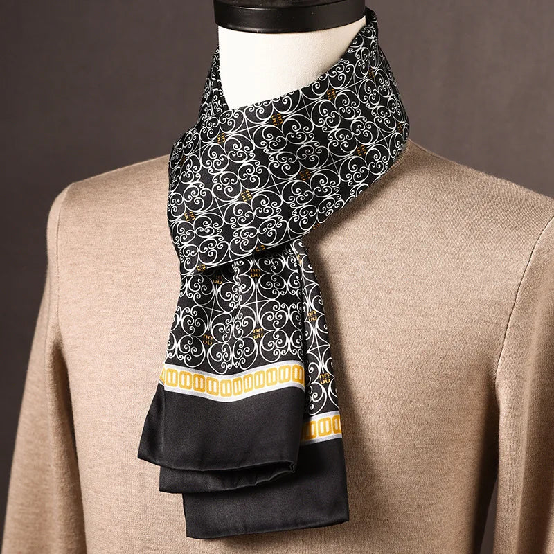 Foulard en soie noir à arabesques blanches et frise dorée, noué autour du cou d'un mannequin en pull beige. 25