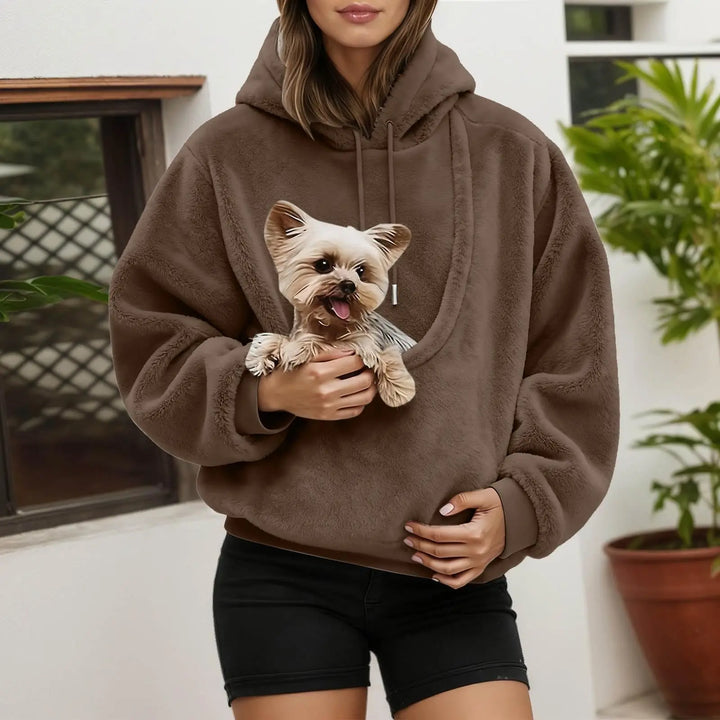 Sweat à capuche marron en polaire douce, porté en extérieur, avec un petit chien blotti dans la grande poche avant. 3