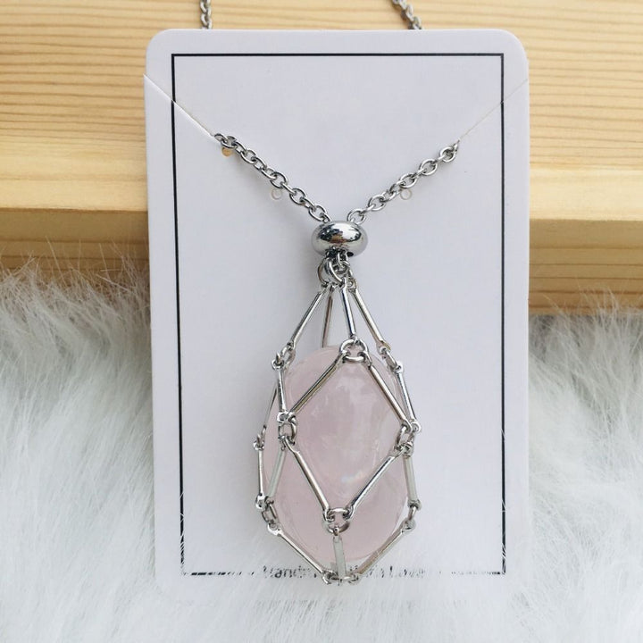 Collier argenté dont le filet de maillons retient une pierre rose très pâle ovale, sur une carte blanche. 11