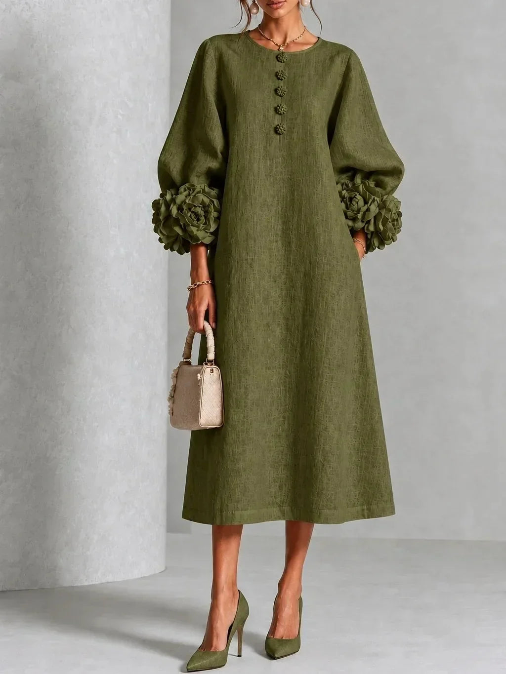 Version vert olive de la robe portée de face, manches bouffantes à grosses fleurs, boutons fleuris, sac beige et escarpins verts. 6