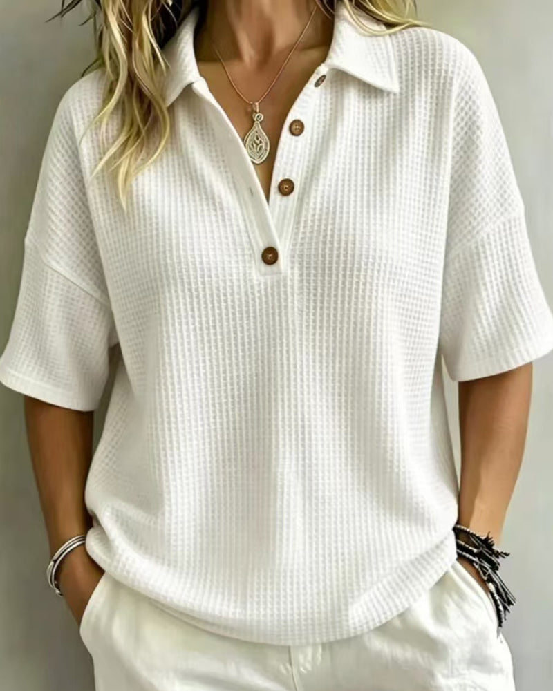 Polo blanc en maille gaufrée porté avec un pantalon blanc, col boutonné à trois boutons en bois 1
