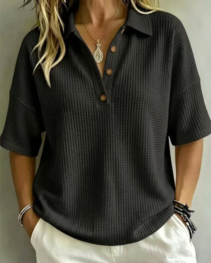 Polo noir en maille gaufrée, vue de face portée, encolure en V boutonnée 5