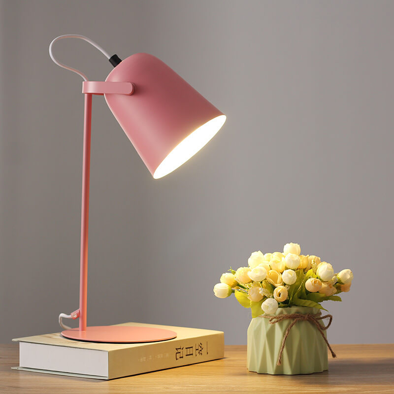 Version rose de la lampe allumée sur un livre, à côté d'un vase vert et de fleurs blanches. 8