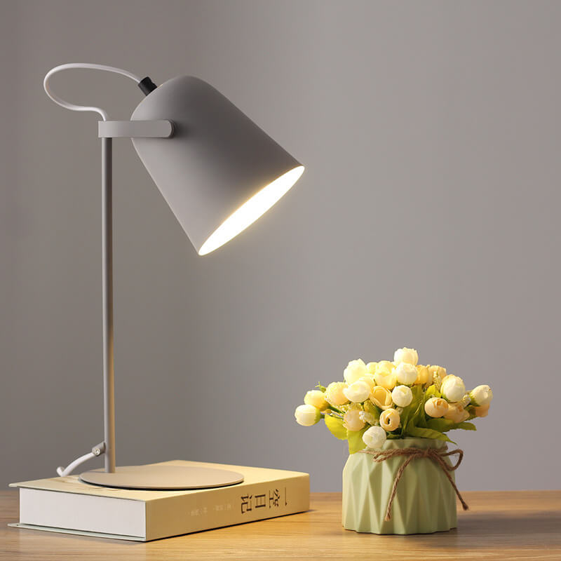 Version grise de la lampe allumée sur un livre, avec un vase vert et un bouquet de fleurs blanches. 10