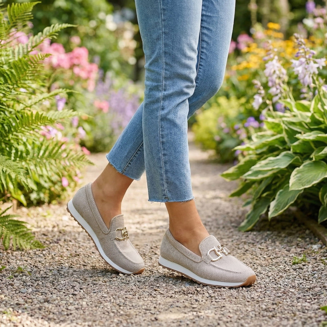 Mocassins beiges portés avec un jean sur un chemin de gravier fleuri 11