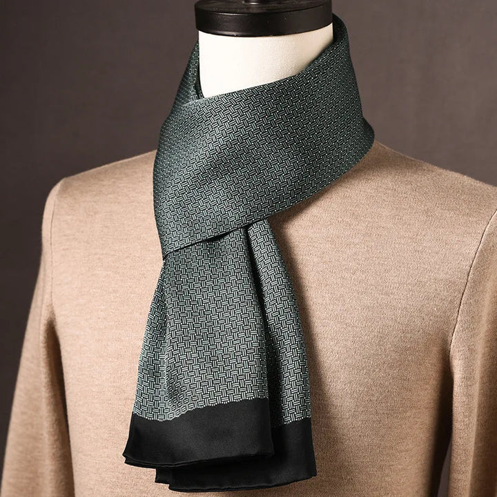 Foulard en soie vert foncé à motif tissé finement quadrillé, bordure noire, drapé sur un mannequin en pull beige. 23