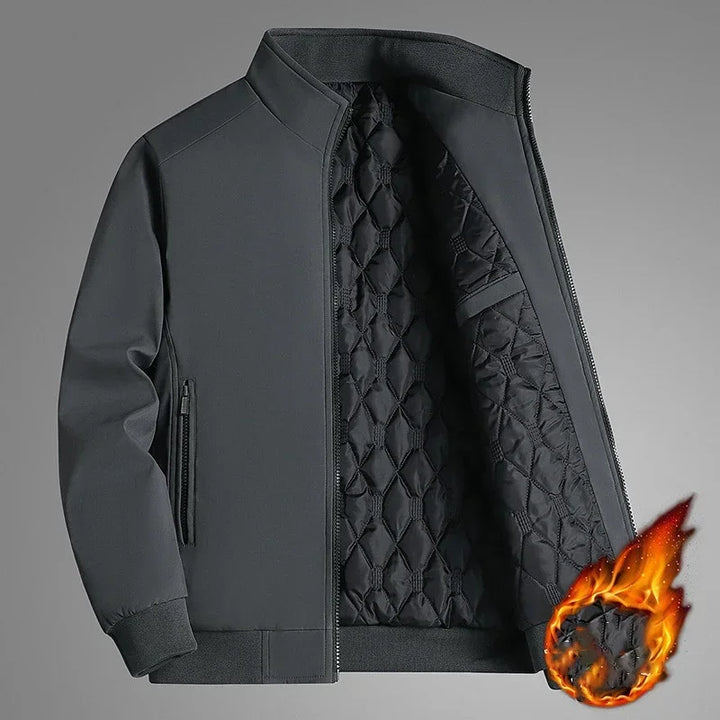 Veste grise à col montant entrouverte montrant la doublure matelassée, avec une boule de flammes illustrant la chaleur. 2