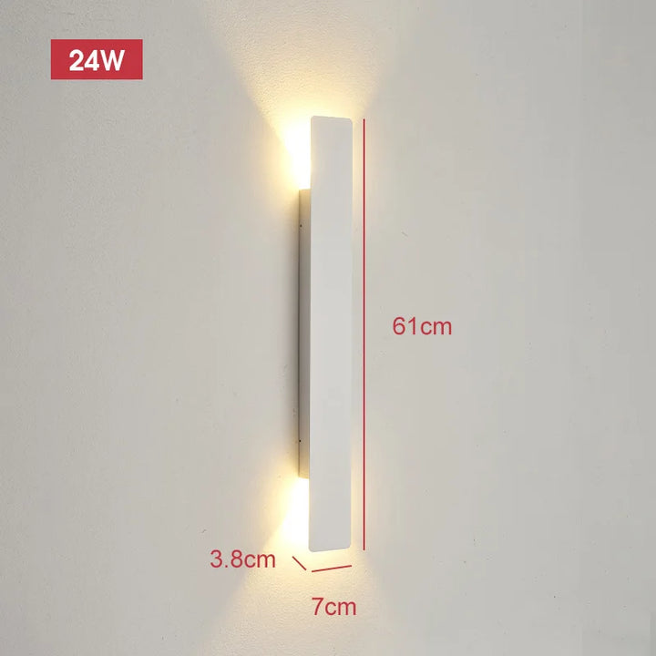 Applique blanche de 61 cm de haut, 7 cm de large et 3,8 cm de profondeur, allumée sur un mur clair avec ses cotes indiquées. 8
