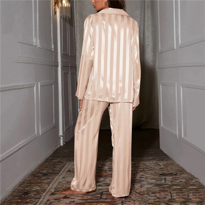 Femme vue de dos dans un couloir, pyjama satiné rayé beige, rayures verticales sur la chemise et le pantalon 2