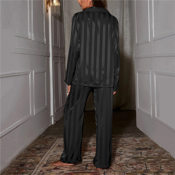 Femme vue de dos dans un couloir, pyjama satiné rayé noir, rayures verticales sur la chemise et le pantalon 5