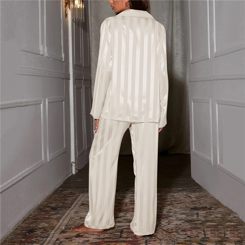 Femme vue de dos dans un couloir, pyjama satiné rayé blanc crème, rayures verticales sur la chemise et le pantalon 8