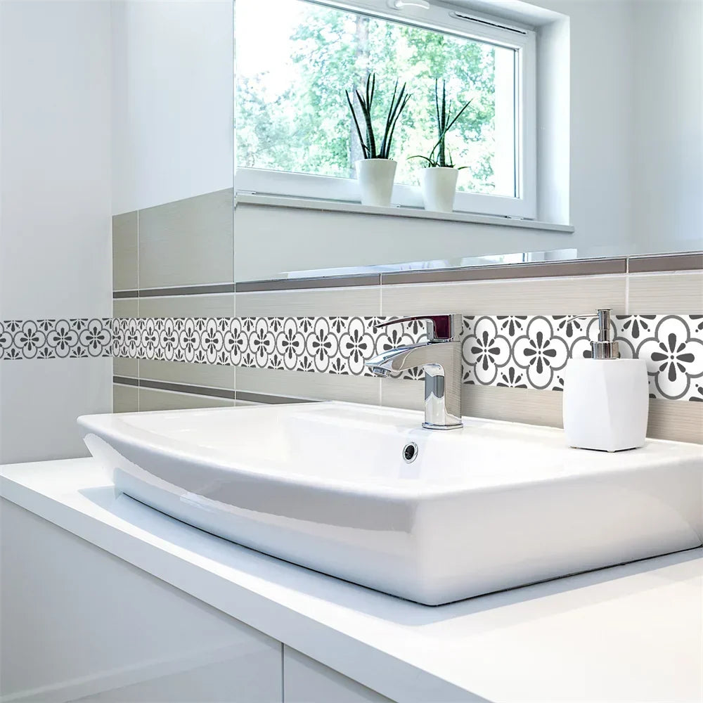 Frise blanche à fleurs grises sur le mur derrière un lavabo blanc et sa robinetterie chromée 9