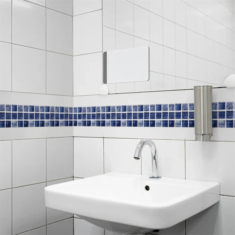 Frise de mosaïque bleu marine au-dessus d'un lavabo suspendu, sur un carrelage blanc 15